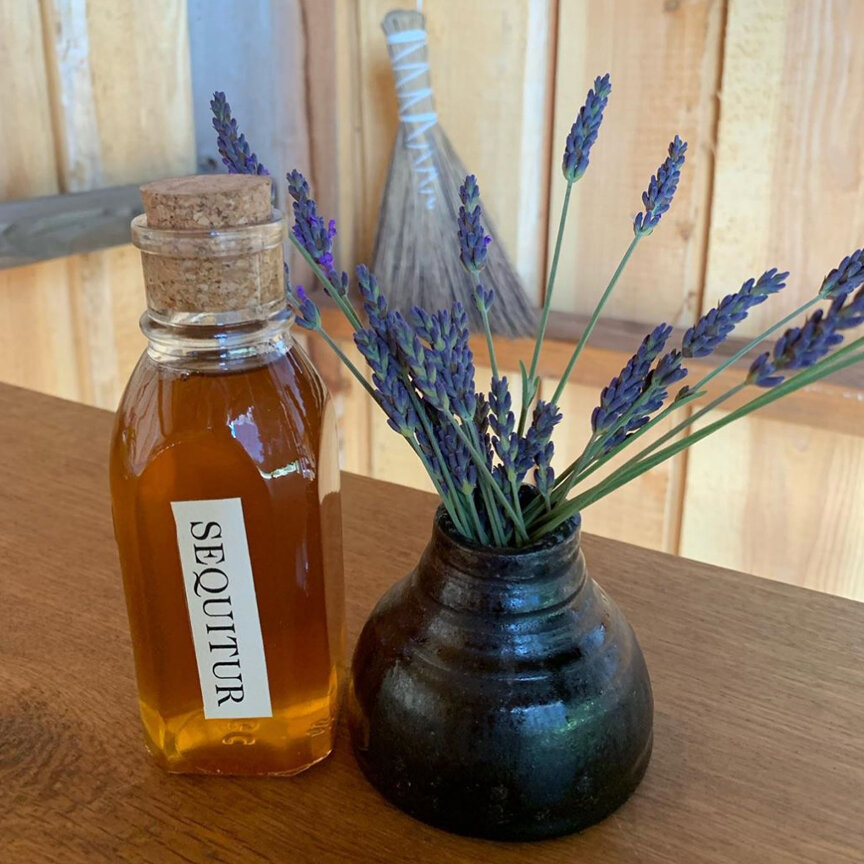 Jar of honey next to a small vase of lavender
